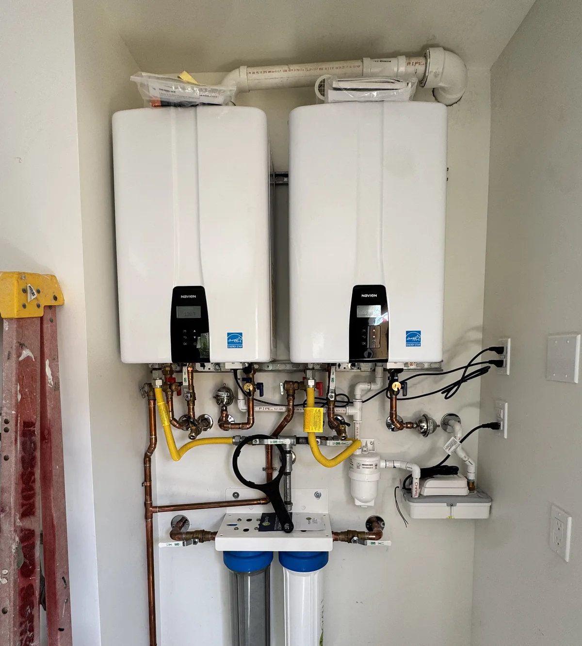 Dual tankless water heaters installed with whole-home pre-filtration