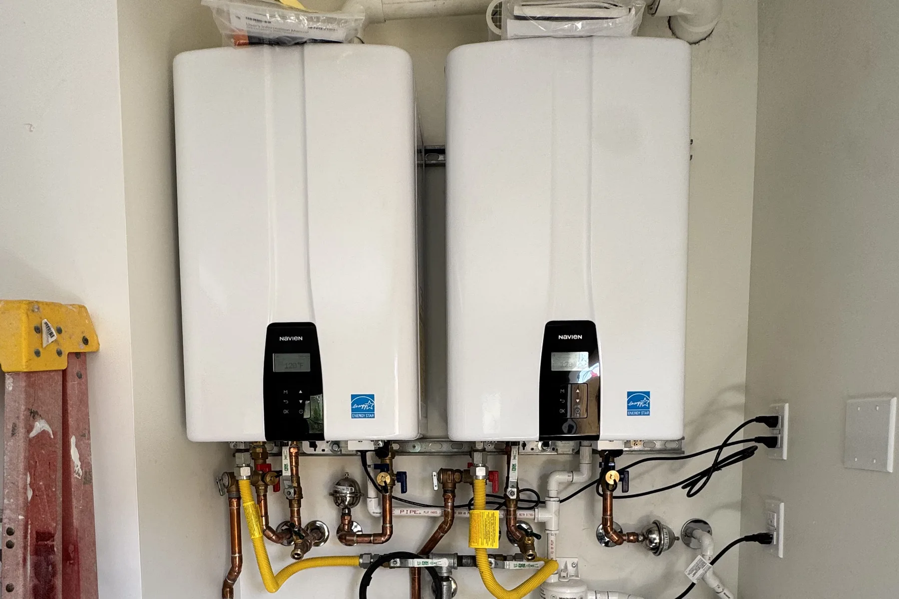 Dual tankless water heaters installed with whole-home pre-filtration