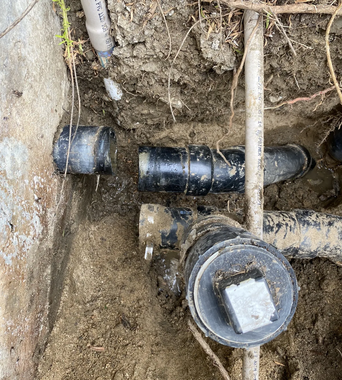 Old cast iron sewer pipe exposed in a trench for repair