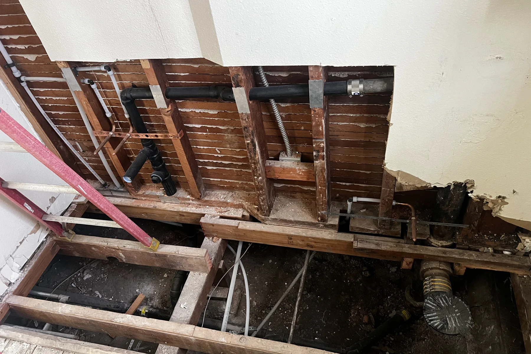 Floor opened to access and repair leaking pipes under a home